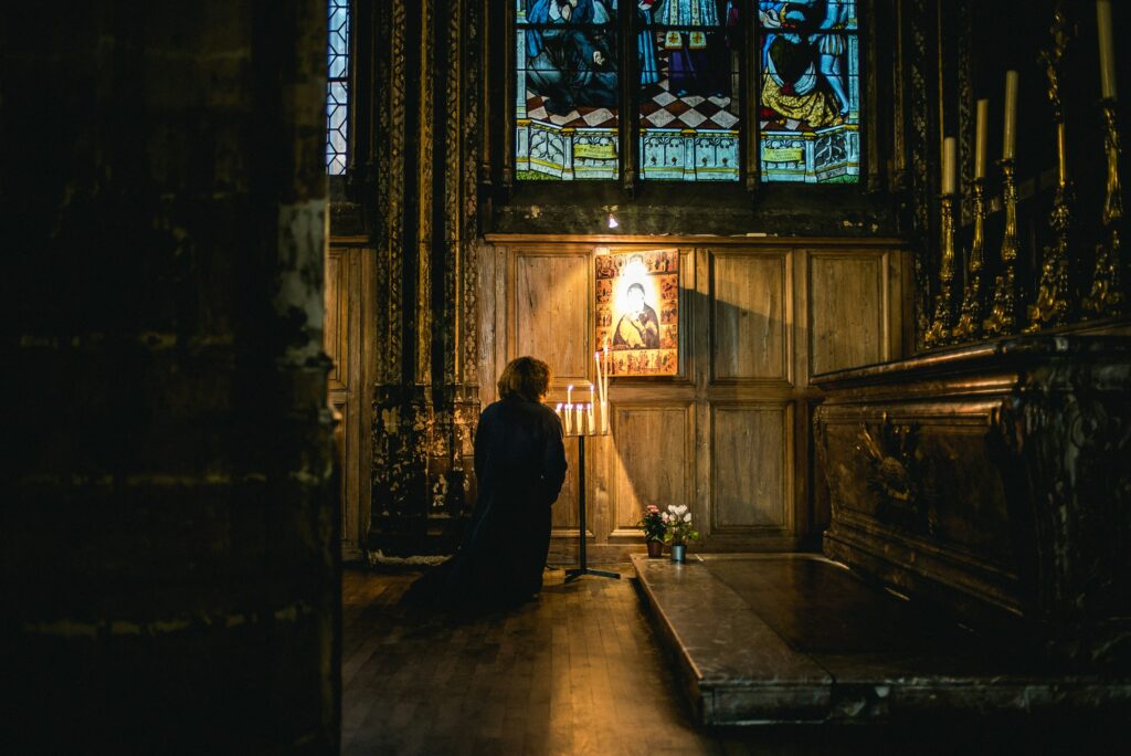 Person praying in a Chuch catholic radio