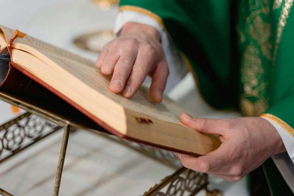 Bible being touched by Priest's hand at Catholic Mass