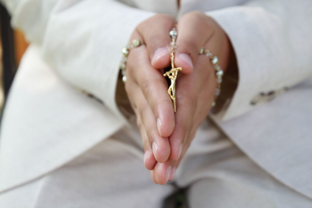 Holding popular Catholic devotions, the Rosary in hands while praying